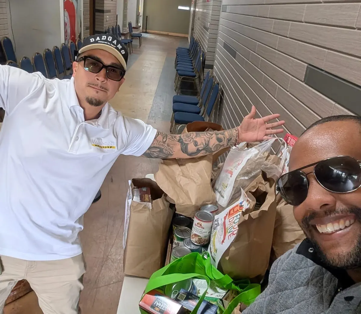 Two team members with bags of donated food